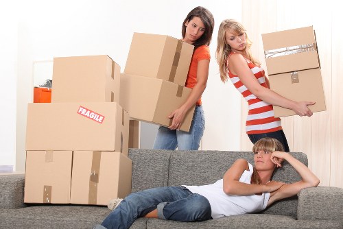 Local moving team handling boxes in a Maze Hill apartment building